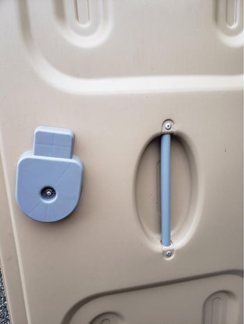 A close up of a plastic door with a blue handle.