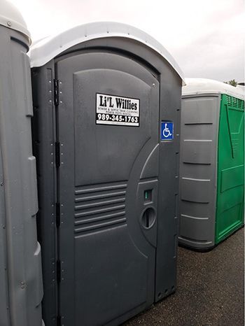 A row of portable toilets are lined up in a parking lot.