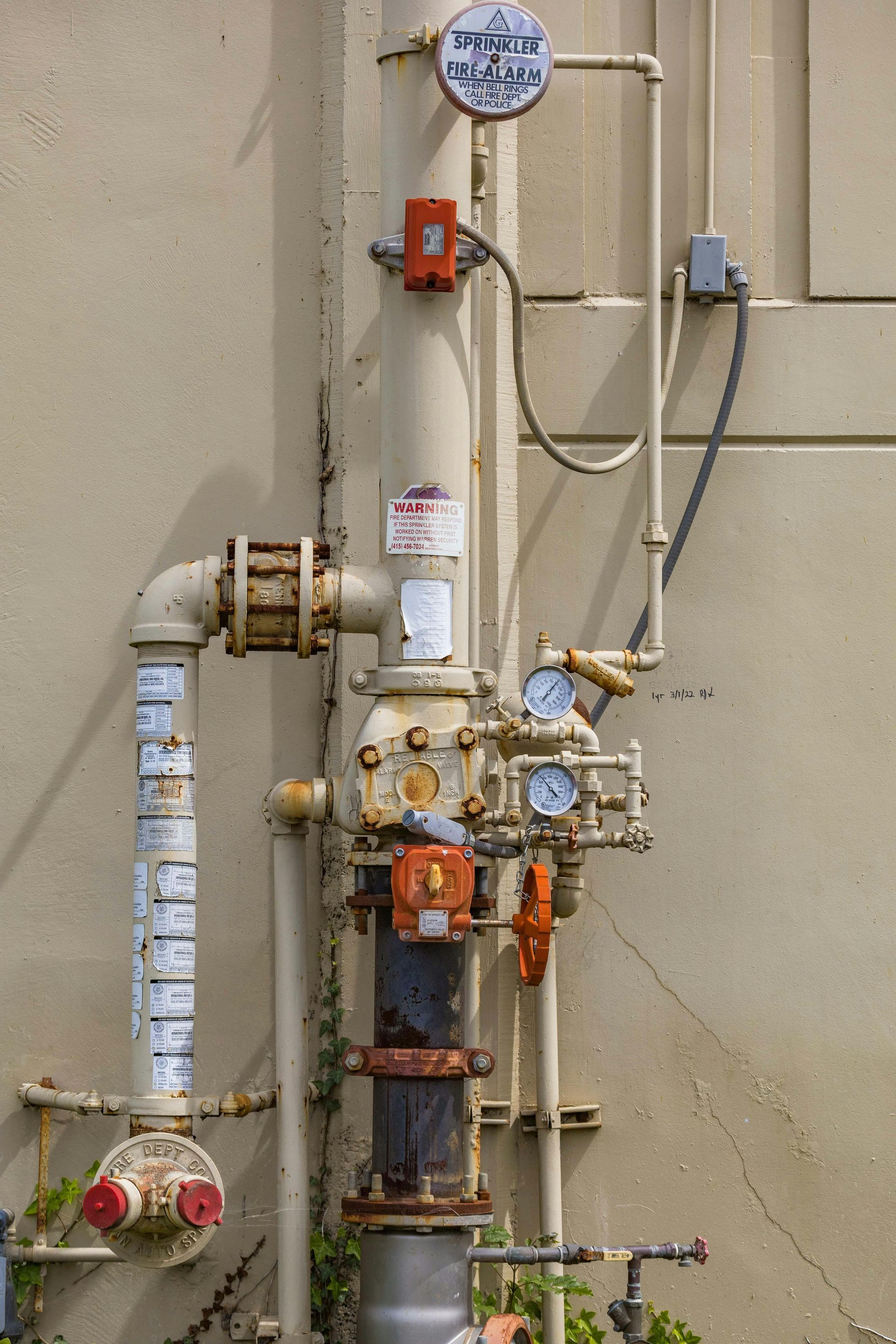 A fire hydrant is attached to the side of a building