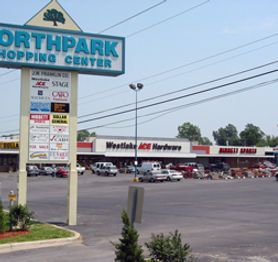 A sign for northpark shopping center is in front of a parking lot