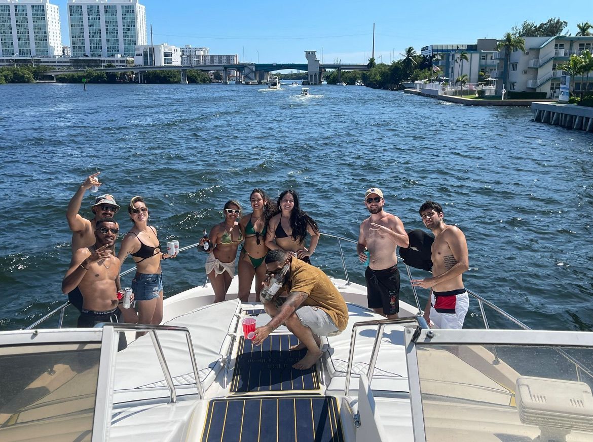 A group of people are standing on the back of a boat in the water.