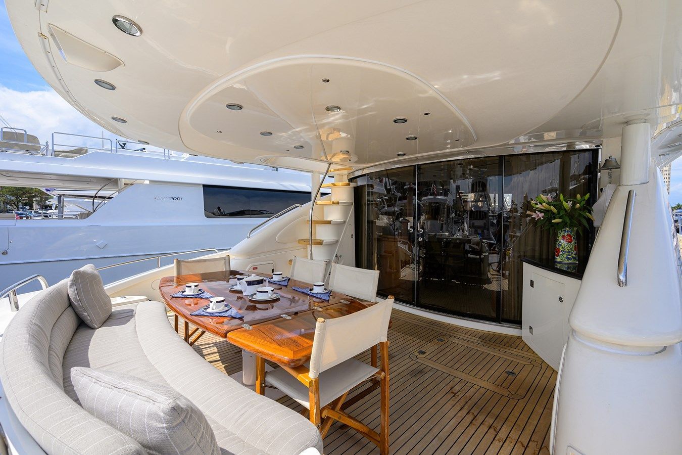 There is a table and chairs on the deck of a yacht.