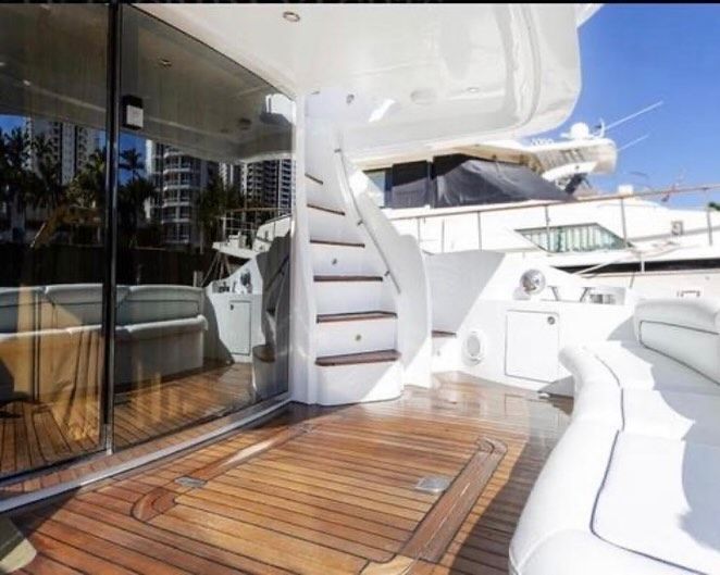 A white boat with wooden deck and stairs