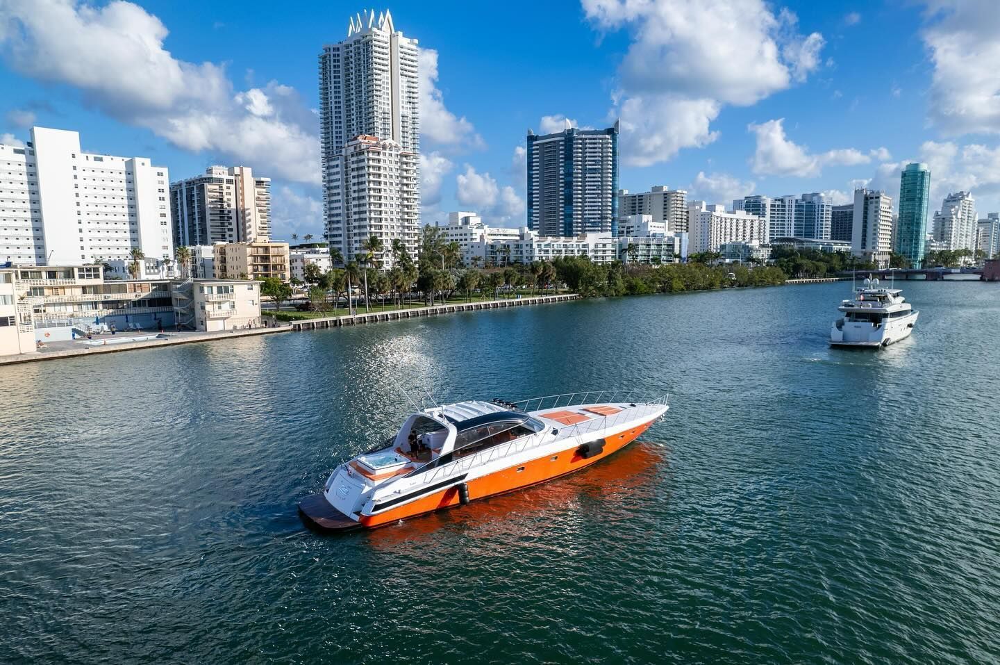 A boat is floating on a body of water with a city in the background.