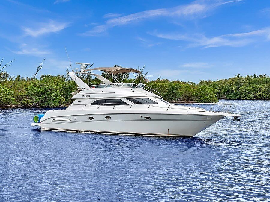 A white yacht is floating on top of a large body of water.