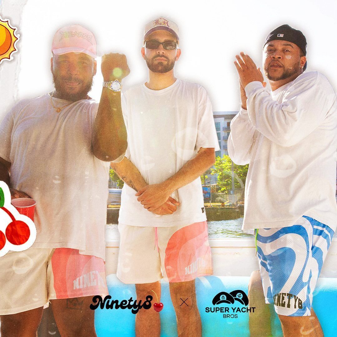 A group of men standing next to each other with a super yacht logo in the background