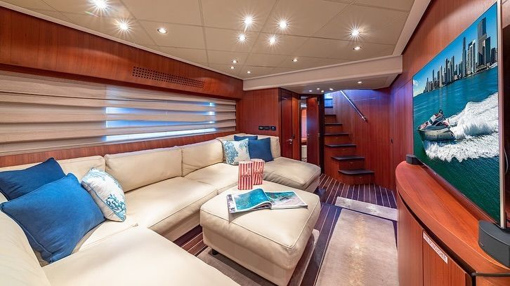 A living room on a boat with a couch and a flat screen tv.