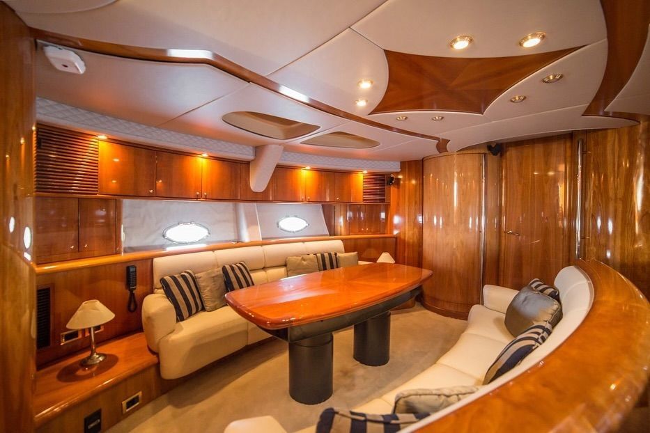 A living room on a yacht with a couch , table and chairs.