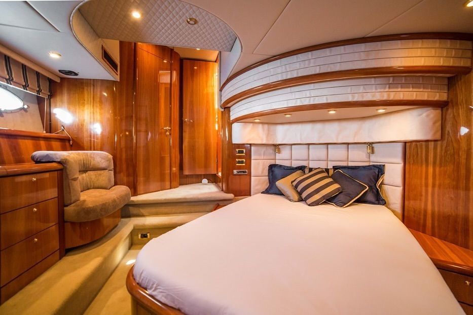 A bedroom on a boat with a large bed and stairs