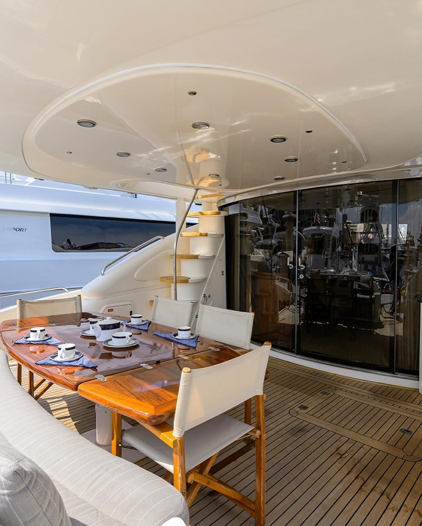 There is a table and chairs on the deck of a boat.