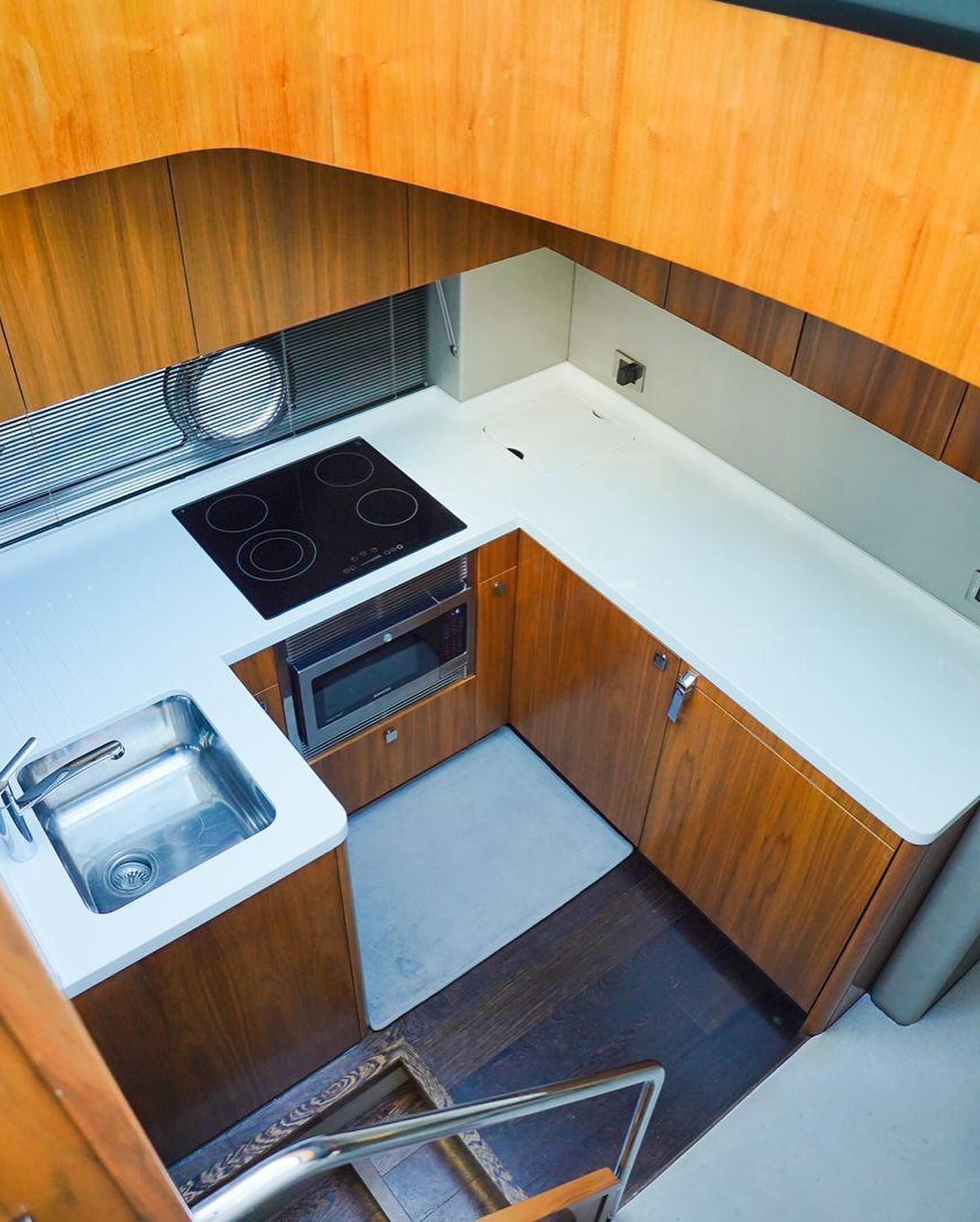 A kitchen with wooden cabinets and white counter tops