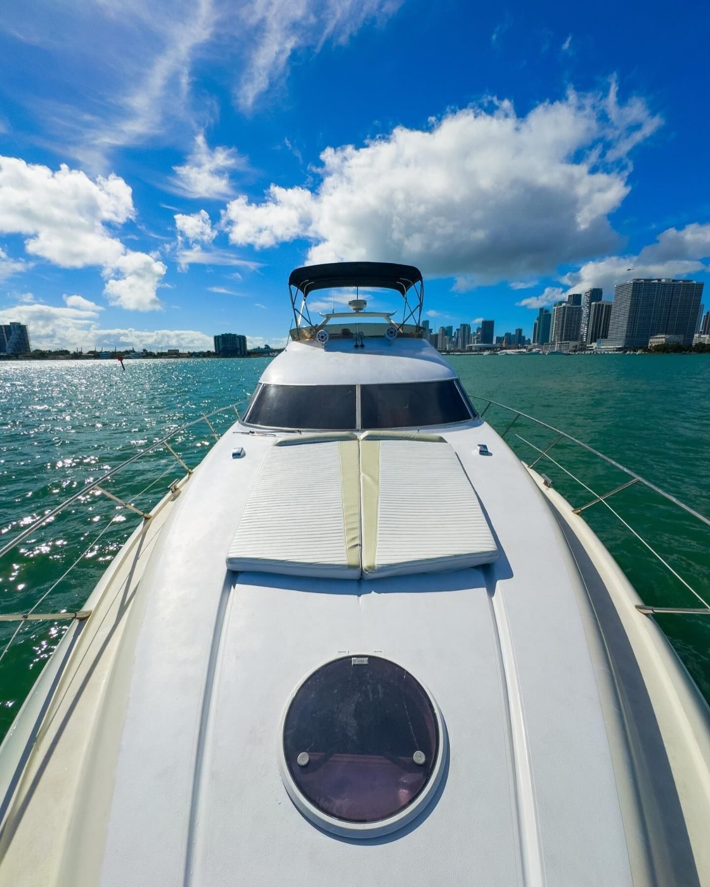 The front of a white yacht is floating on top of a body of water.