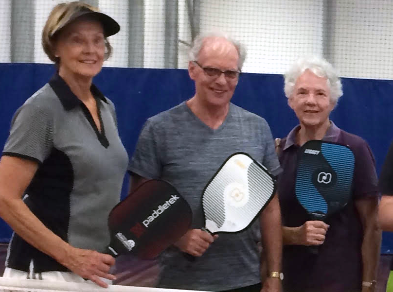 Gold Coast Pickleball founders holding paddles with a coach