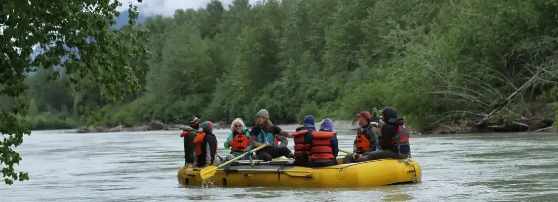 Group on an inflatable raft along floating along Alaska's waterways