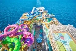 Utopia of the Seas top deck with colorful water slides and pools surrounded by the Caribbean Ocean 