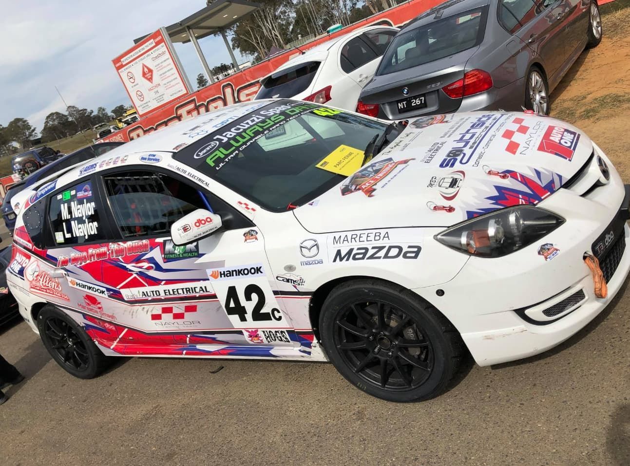 A White Race Car With The Number 42 On The Side Is Parked In A Parking Lot — Brad's Auto Electrical in Mareeba, QLD