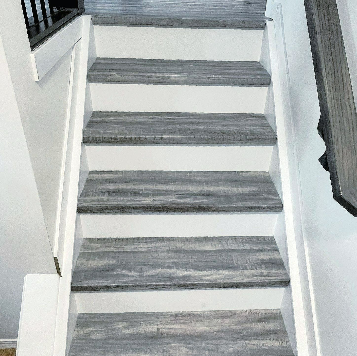 A set of stairs with wooden steps and a white railing