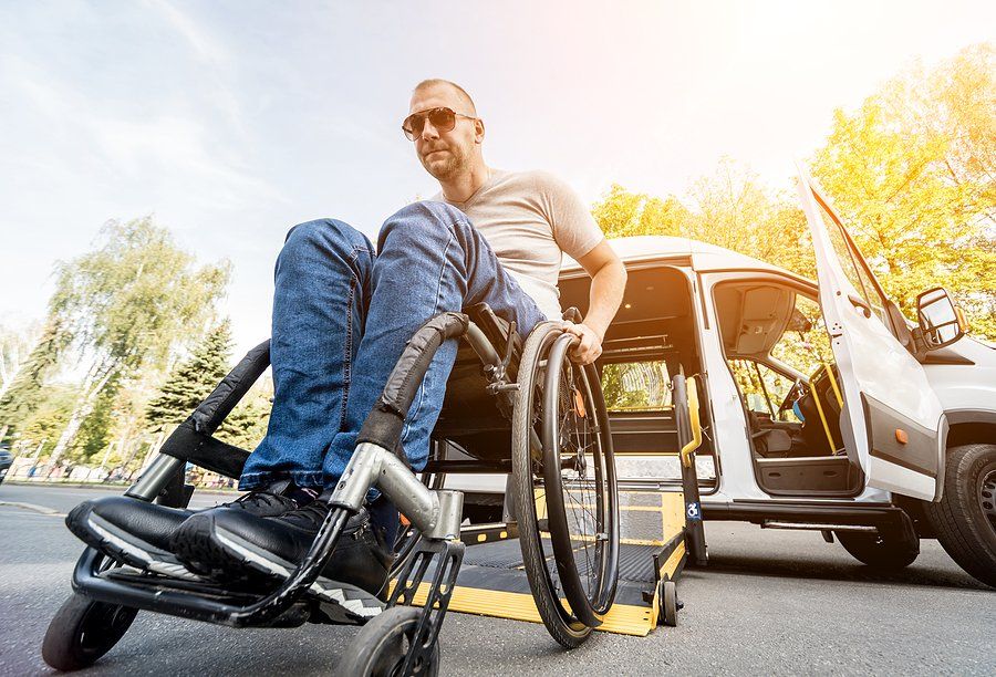 man in the wheelchair beside the van