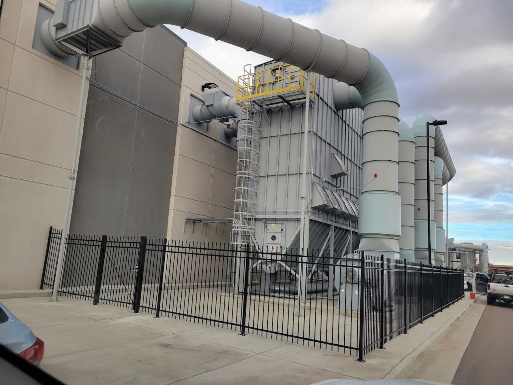 A large industrial building with a fence around it