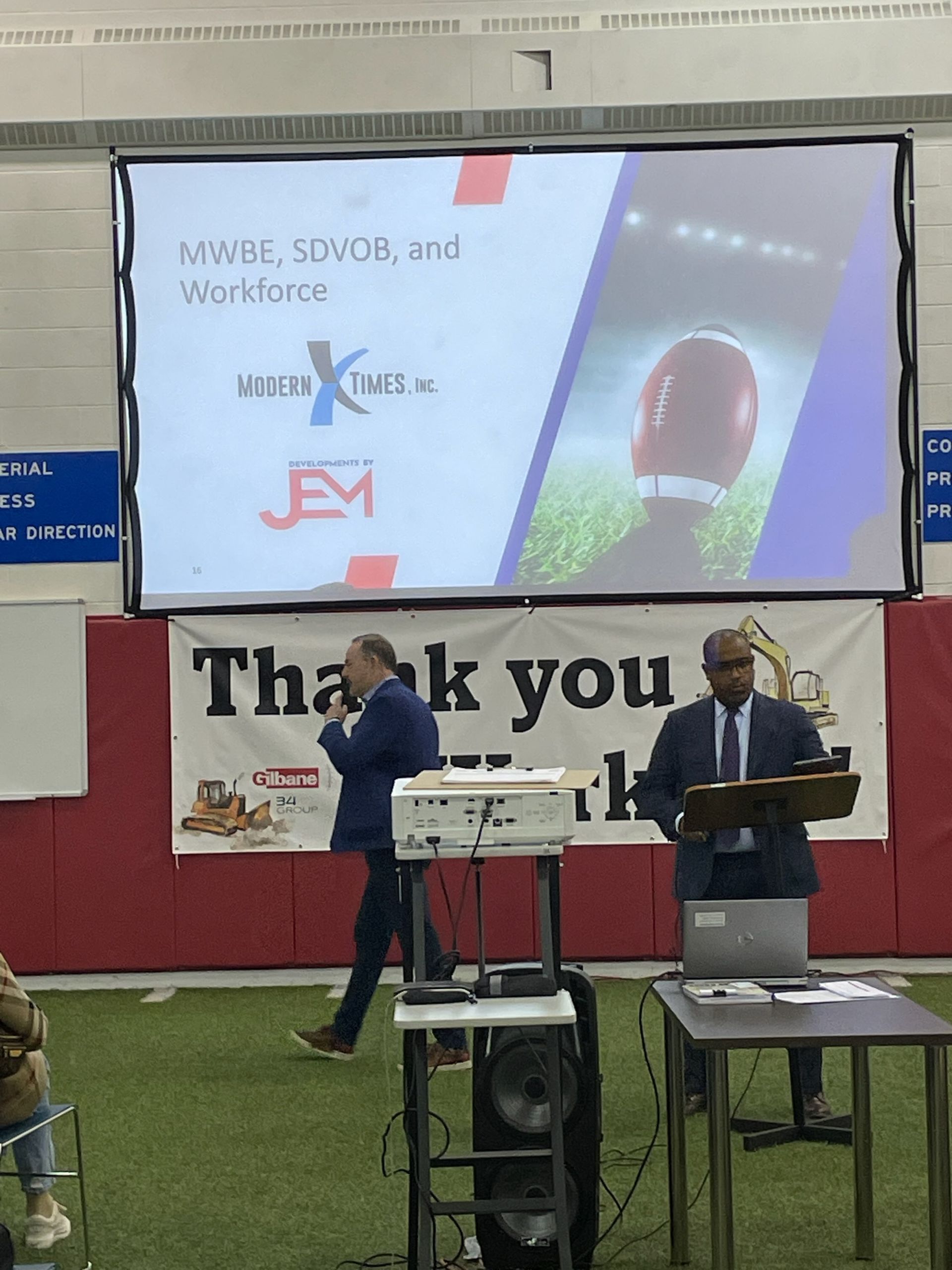 A man giving a presentation in front of a thank you sign