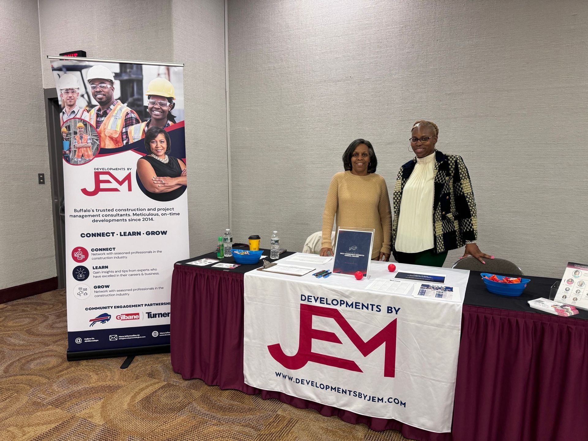 2 women standing at a table at an event