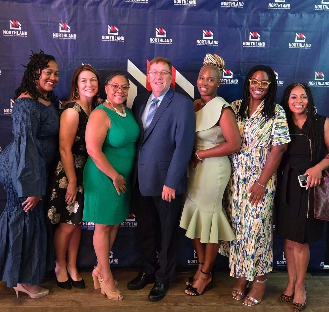 A group of people standing in front of a blue wall