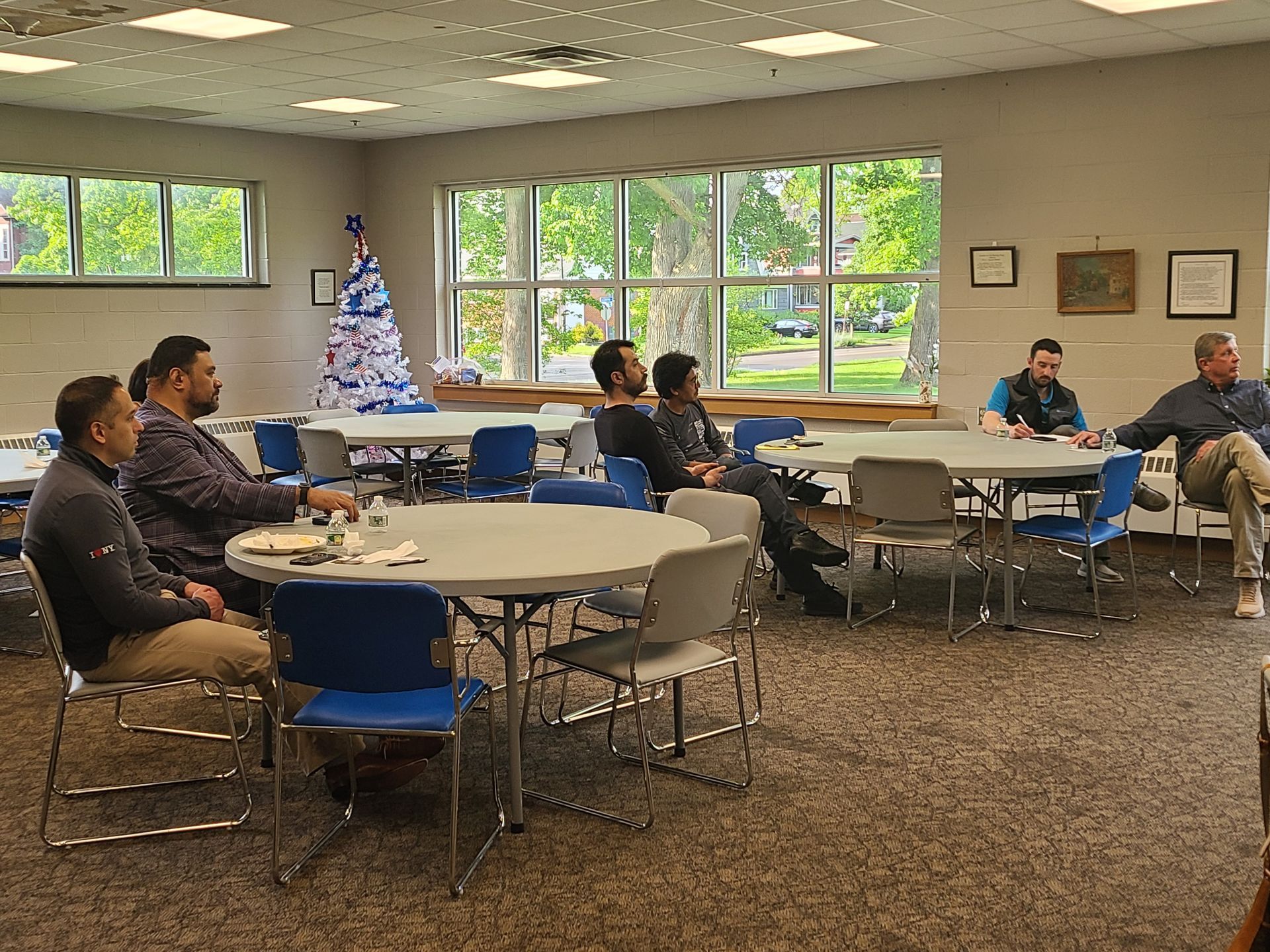 A group of men are sitting at tables in a room.