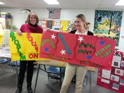 Two women holding up signs that say problem on and action plan