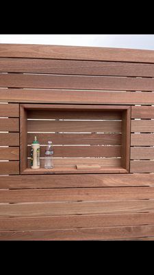 A wooden wall with a shelf in the middle of it.