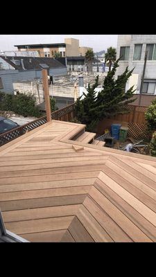 A wooden deck is being built on top of a house.