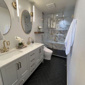 A bathroom with two sinks , a toilet , and a shower.