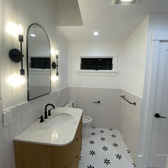 A bathroom with a sink a toilet and a mirror