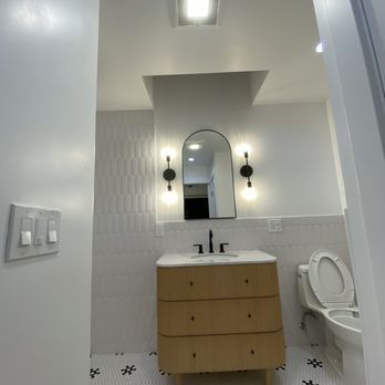 A bathroom with a toilet a sink and a mirror
