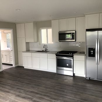 A kitchen with stainless steel appliances and white cabinets.