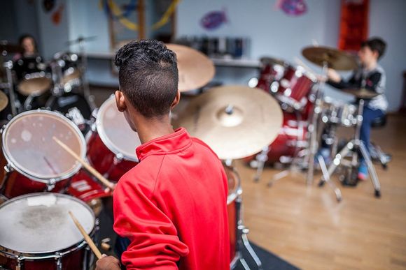 boy practicing playing drums