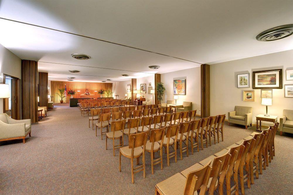 A large room with rows of chairs and a couch.