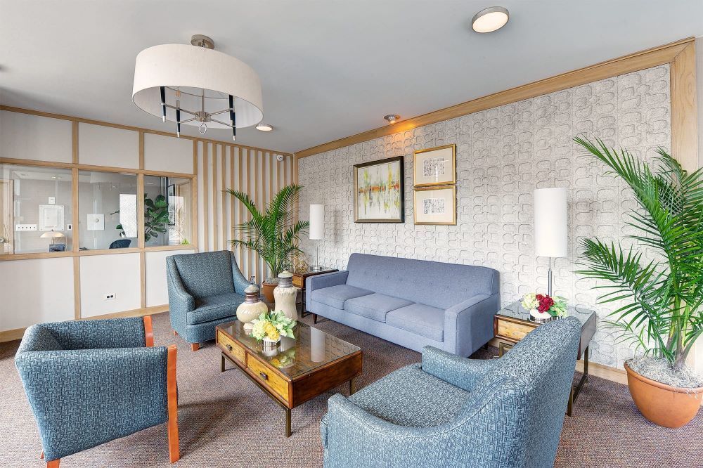 A living room with a couch , chairs , and a coffee table.