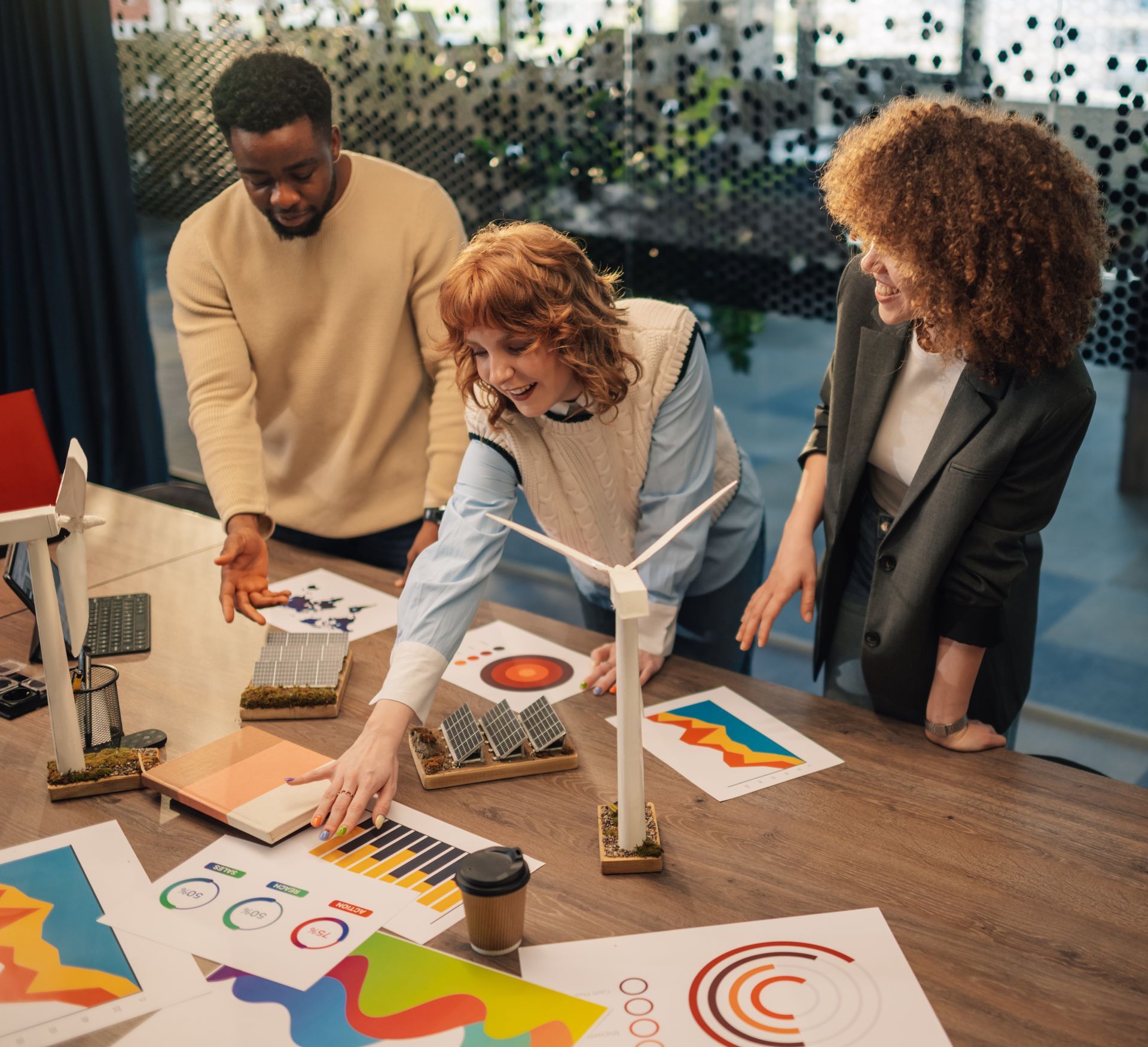 A group of people are looking at a wind turbine on a table.