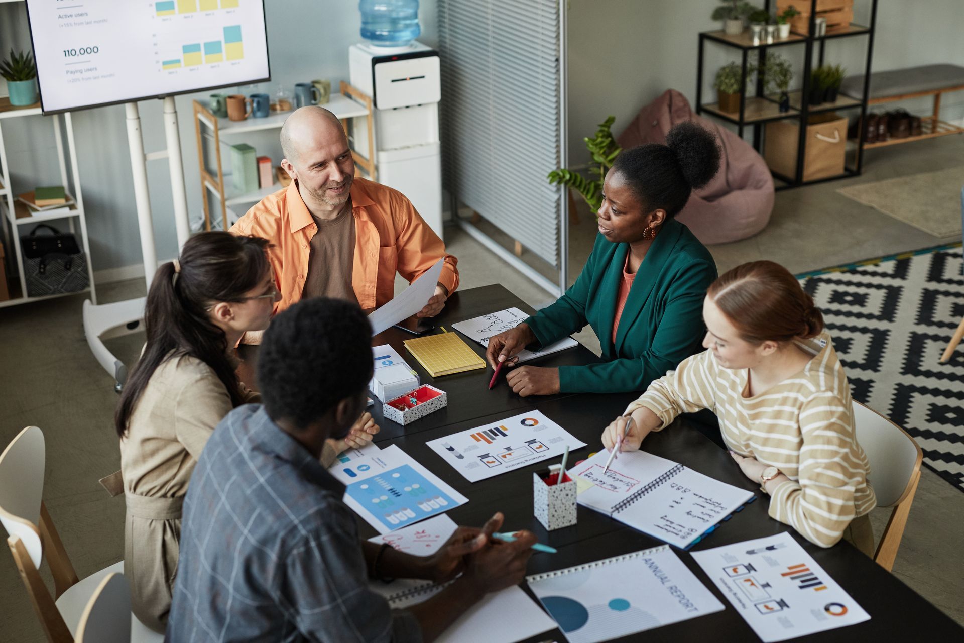 A group of people are sitting around a table having a meeting.