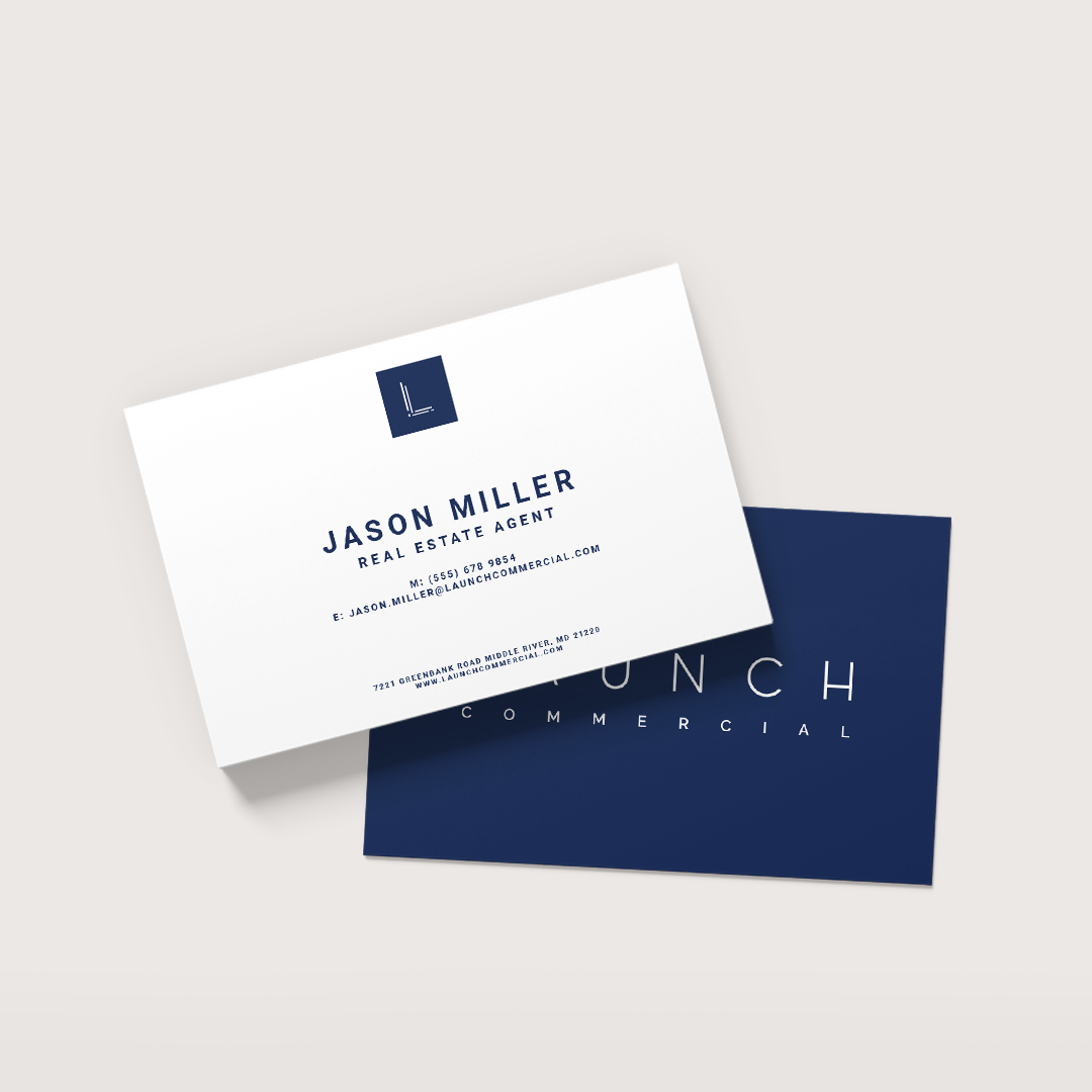 Two business cards are sitting on top of each other on a table.