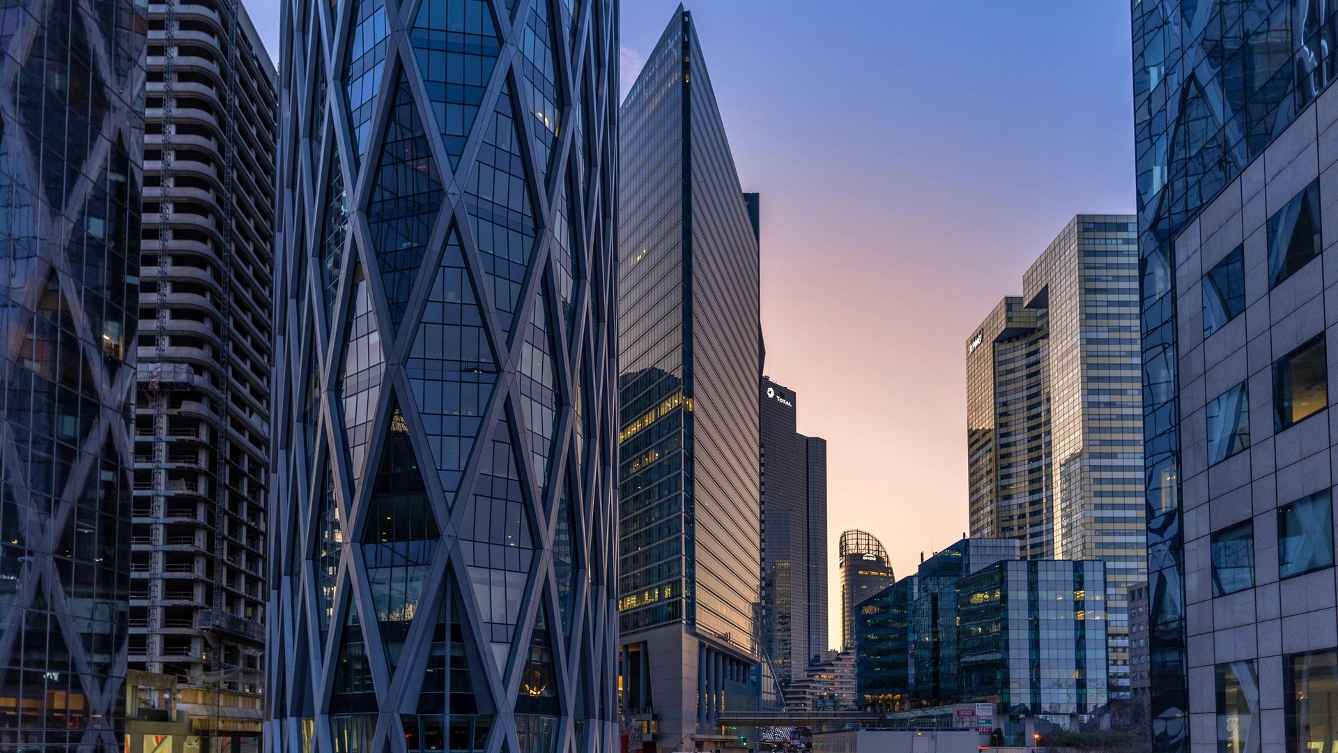 A cityscape with a lot of tall buildings and a sunset in the background.