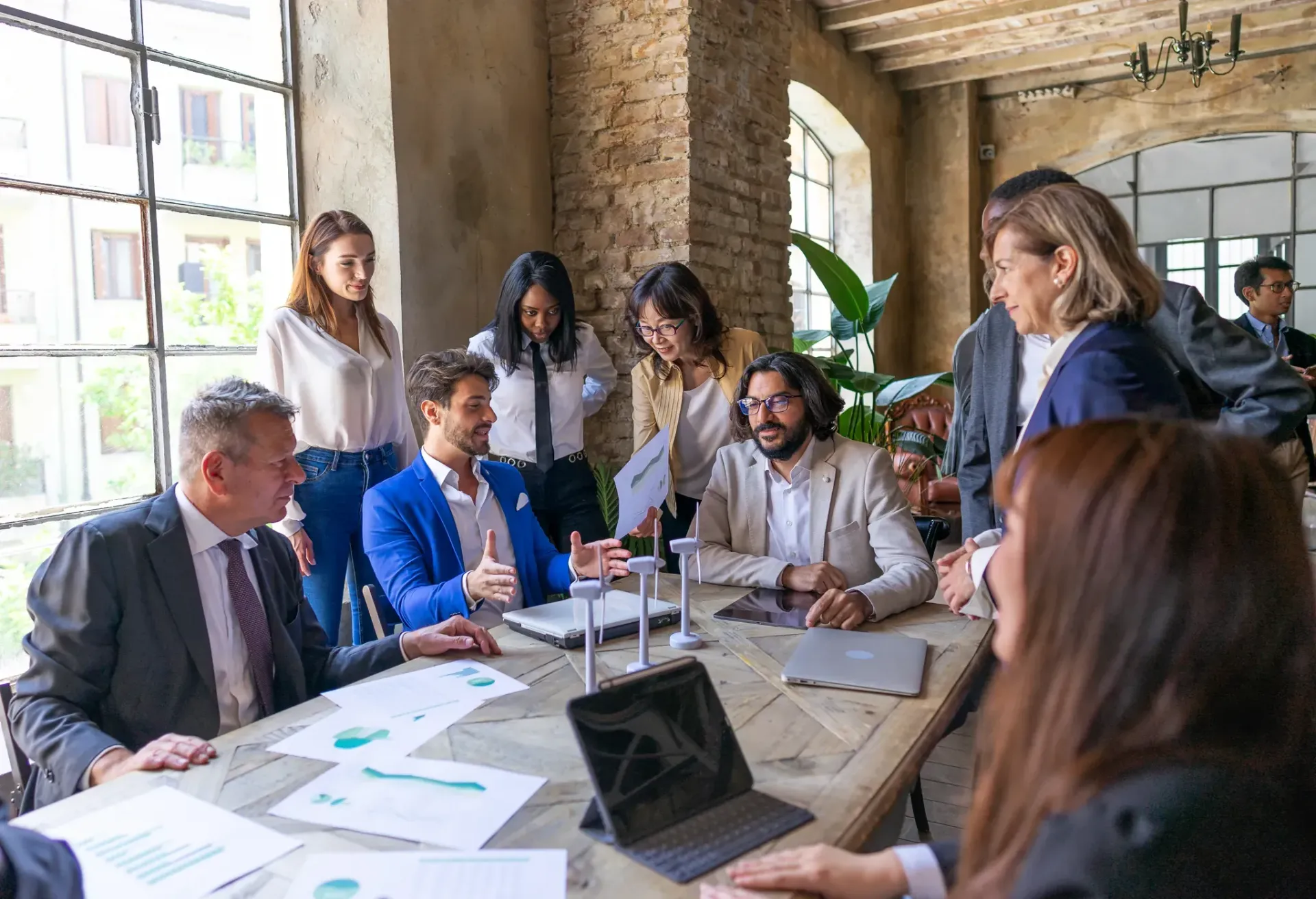 A group of people are sitting around a table having a meeting.