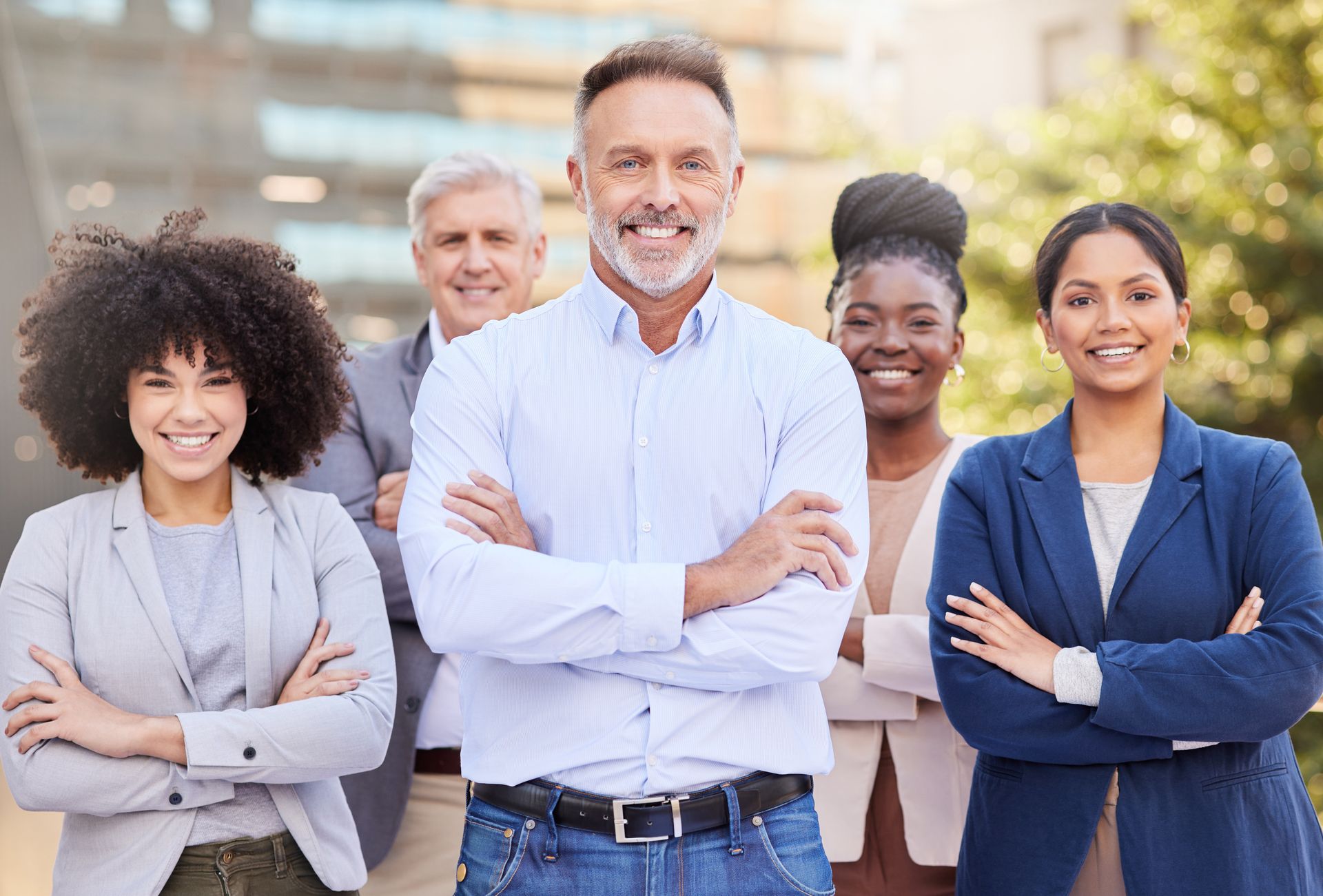 A group of people standing next to each other with their arms crossed.