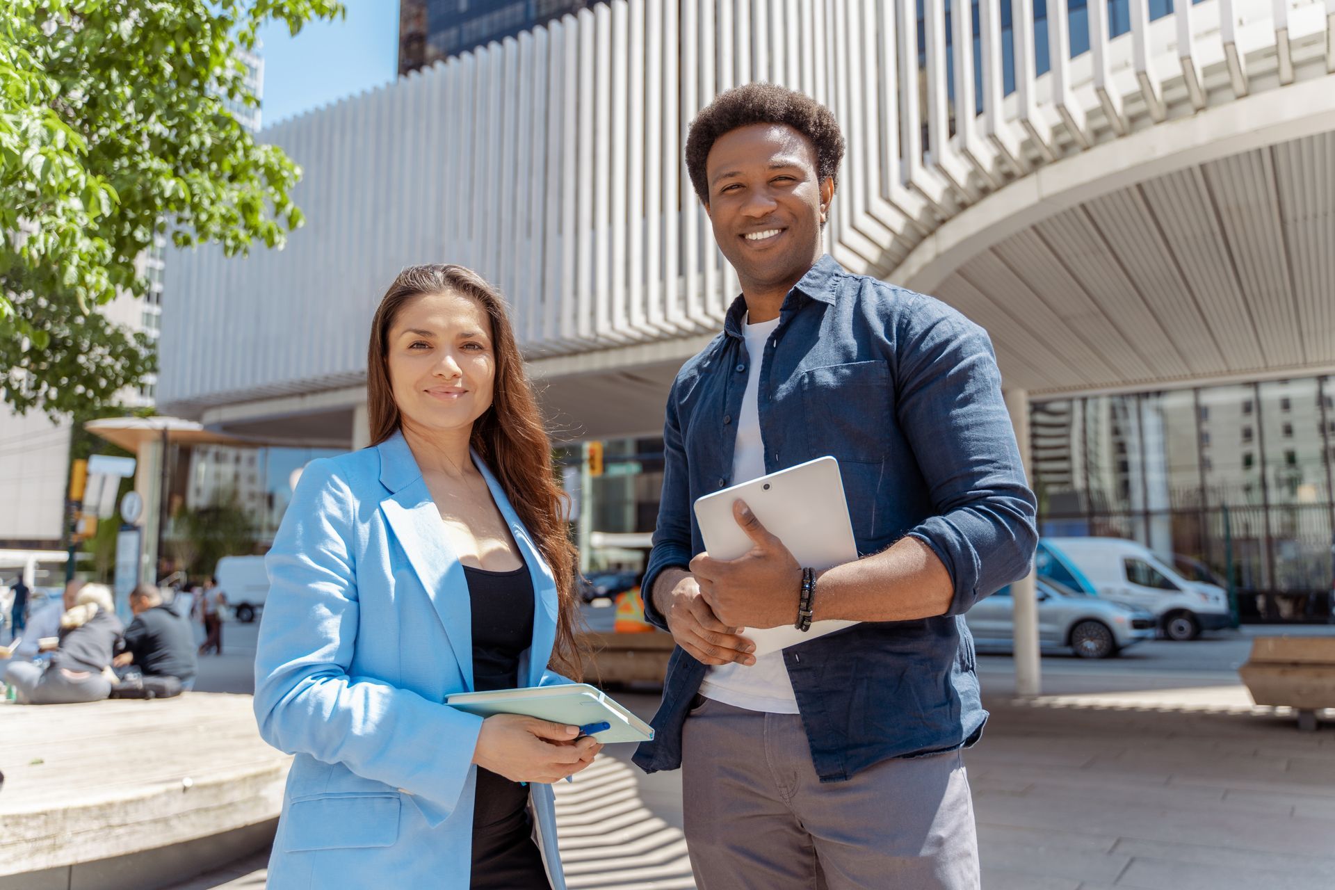 A man and a woman are standing next to each other in front of a building.