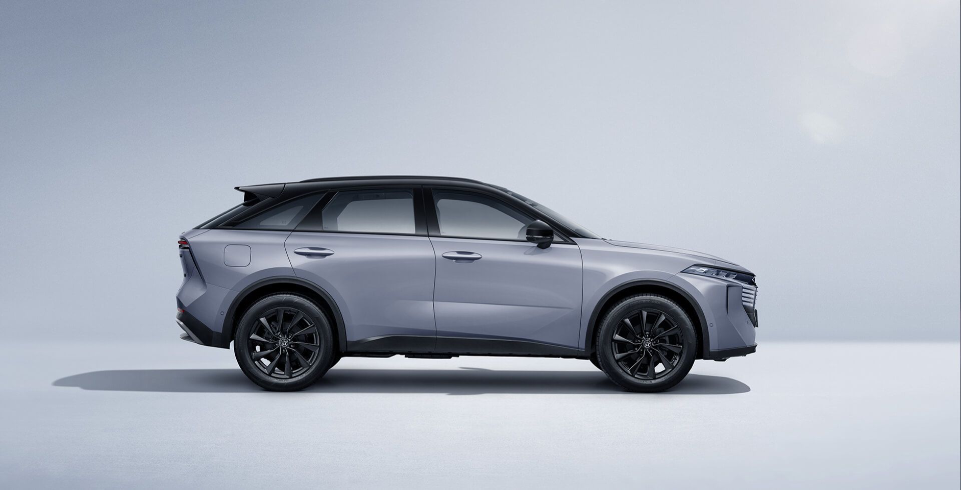 Gray SUV with black wheels and roof, side view against a light gray background.