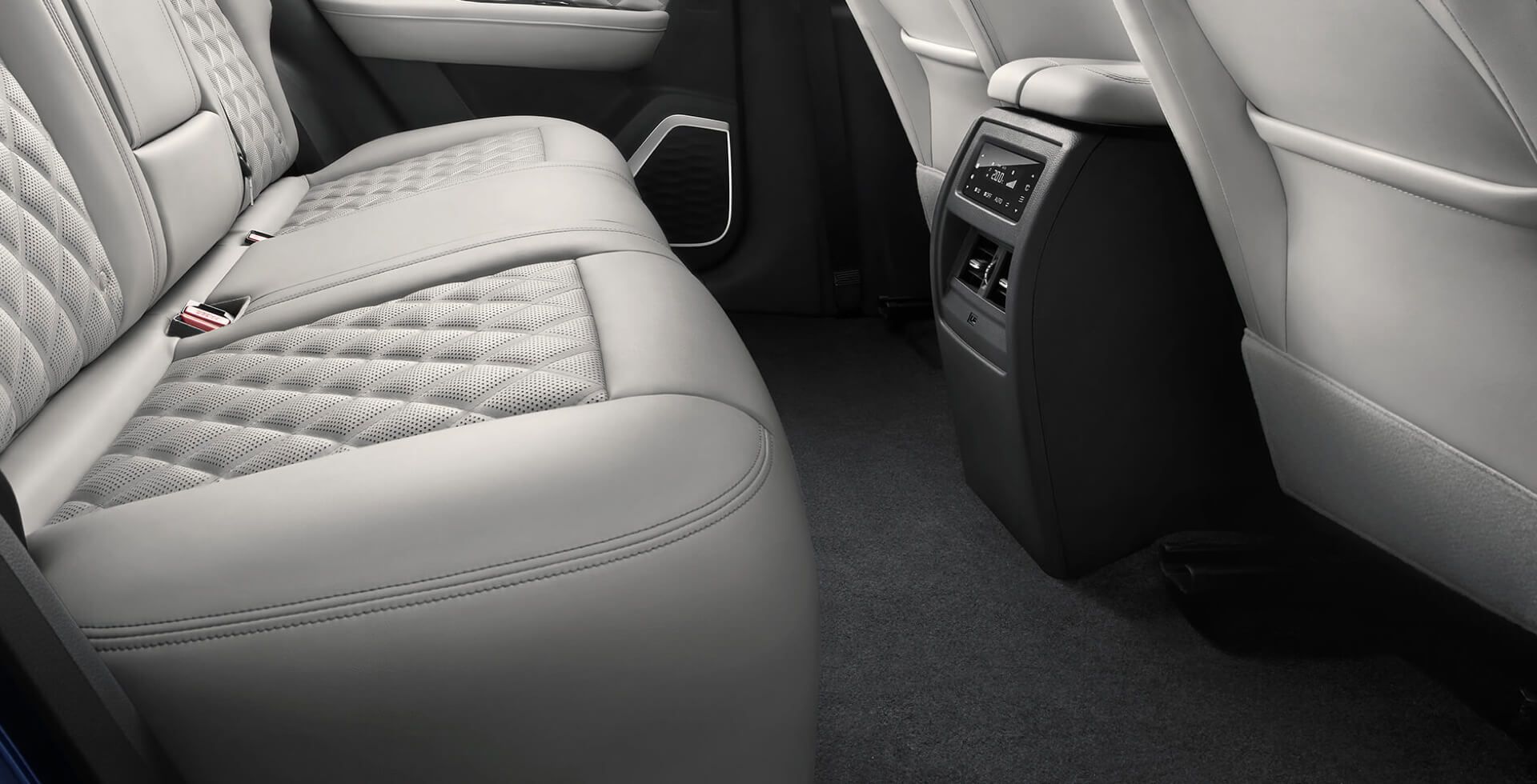 Back seat of a car with light gray leather upholstery, including a center console with controls.