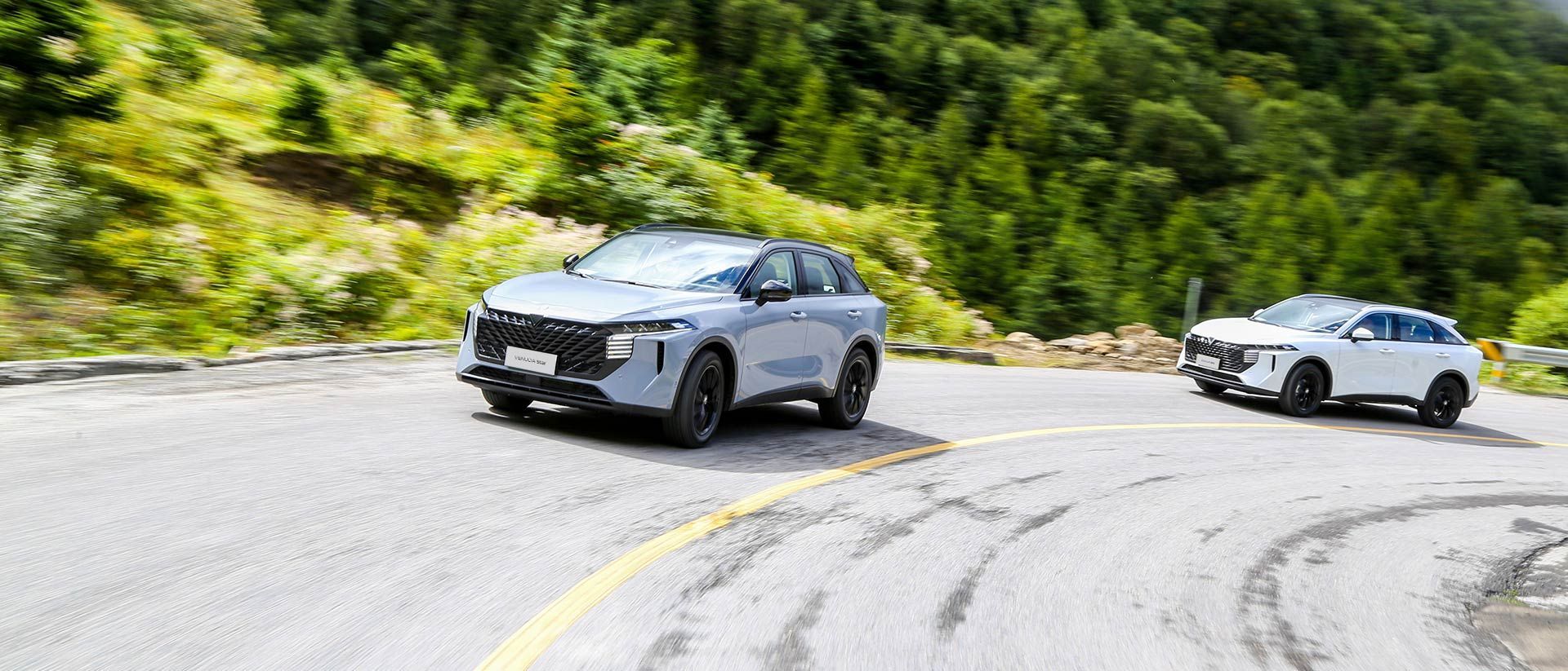 Silver electric SUV in motion with a blurred background of red and blue lights.