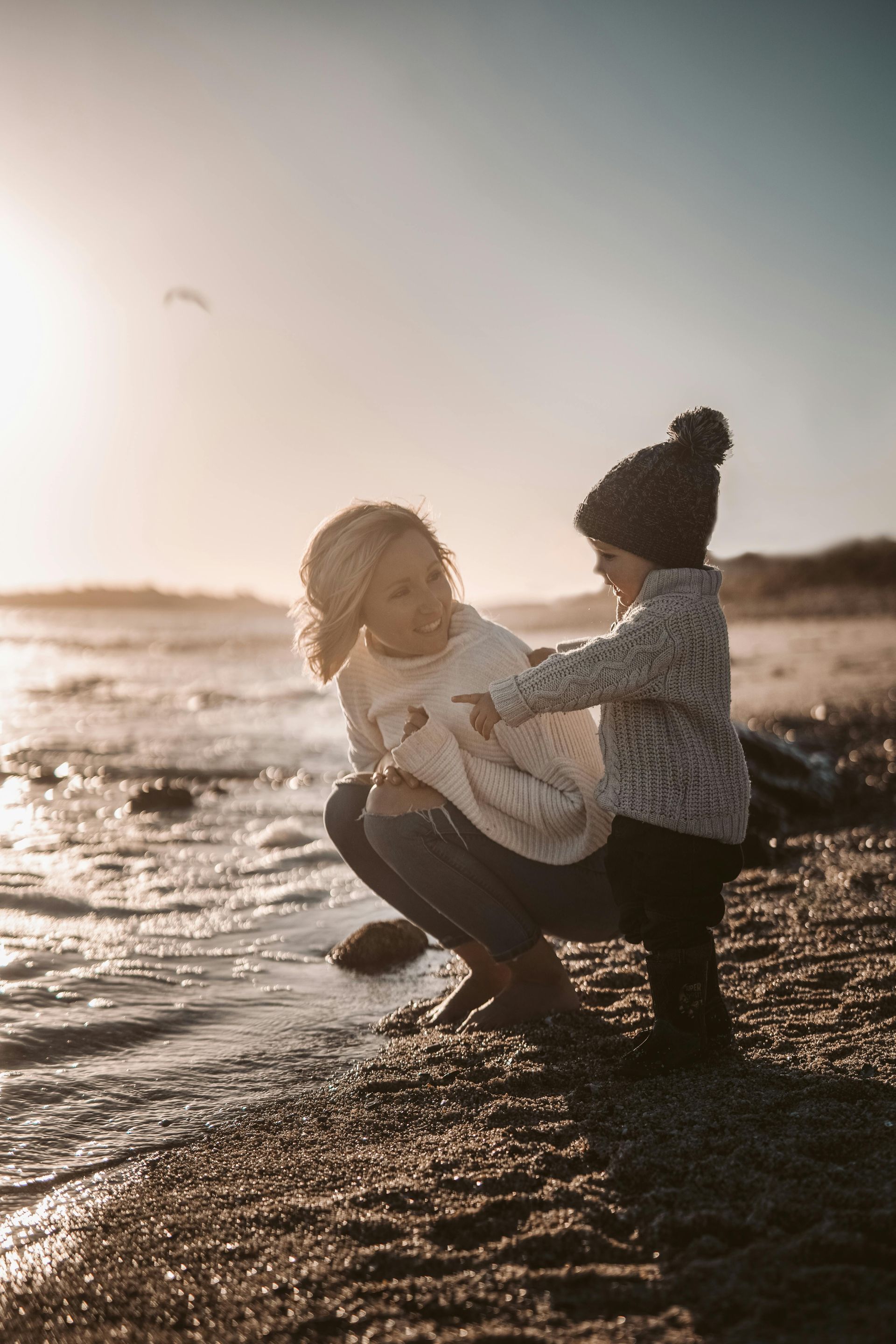 Generational patterns demonstrated by a mother and child on the beach