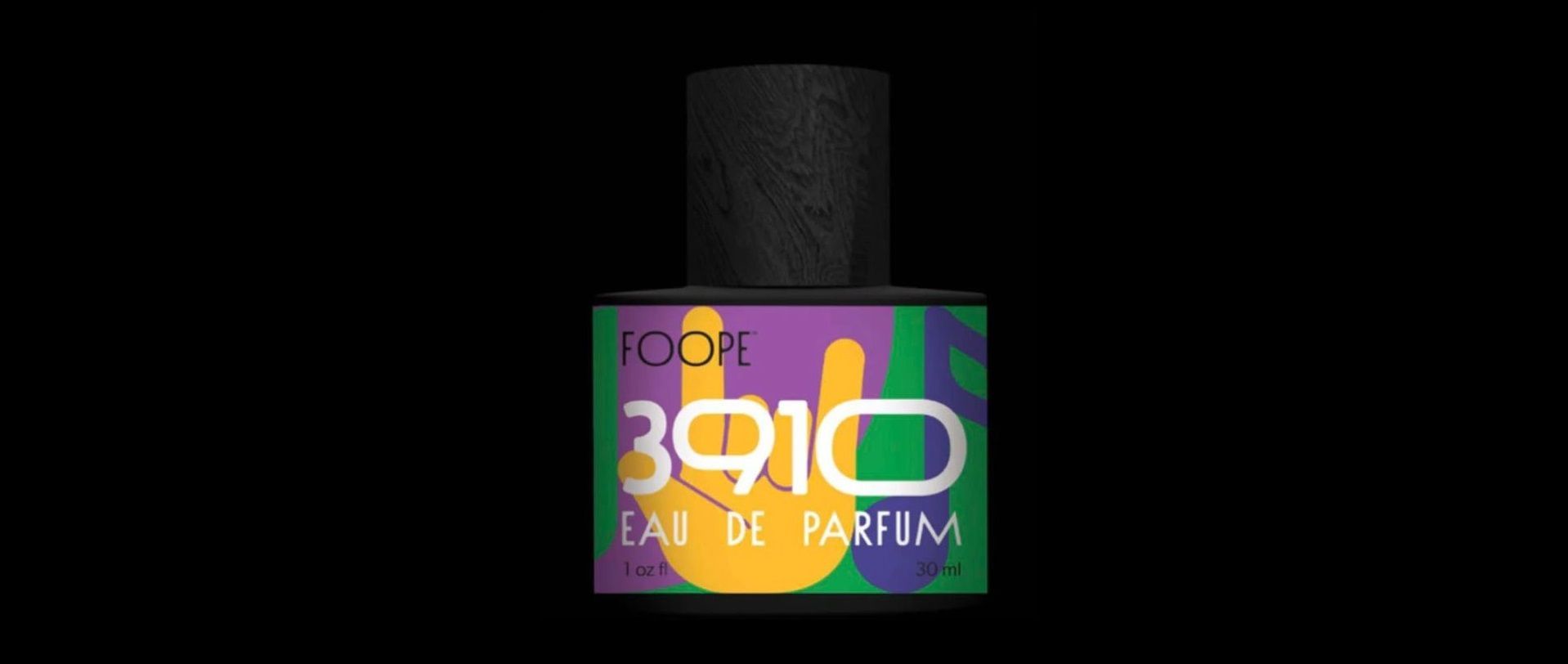 A bottle of perfume with a colorful label on a black background.