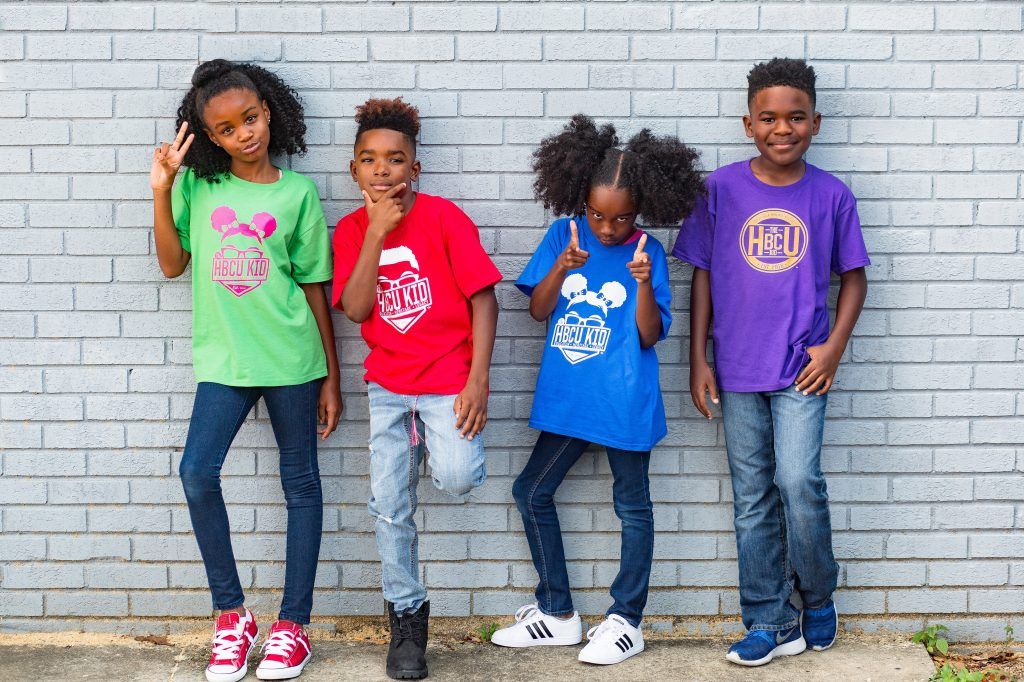 A group of children are standing next to each other in front of a brick wall.